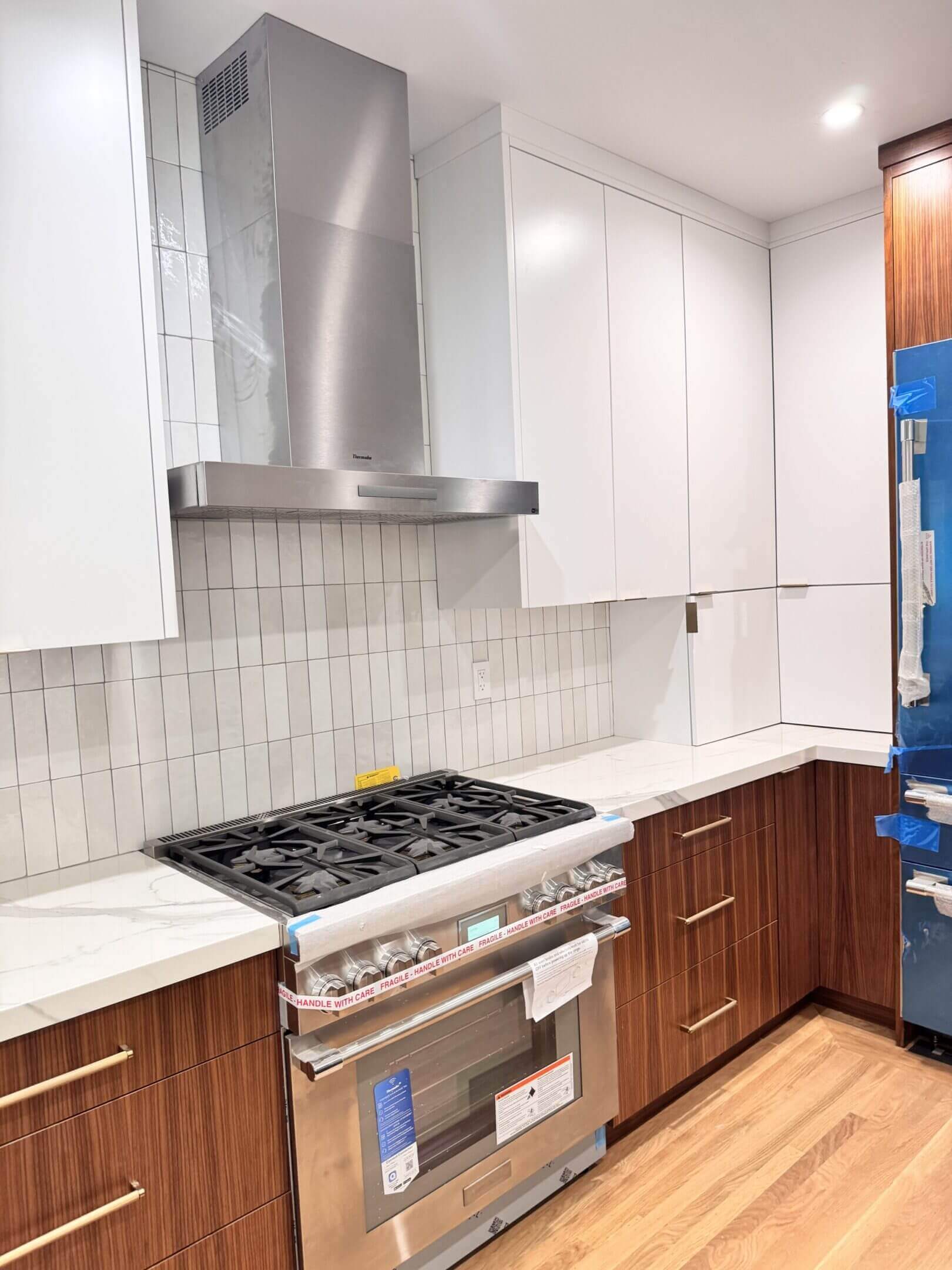 Modern kitchen with stainless steel stove and wooden cabinets.