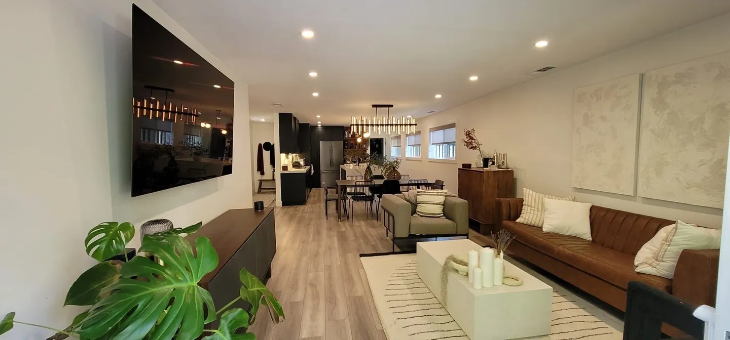 Modern open living room with cozy seating and warm lighting.