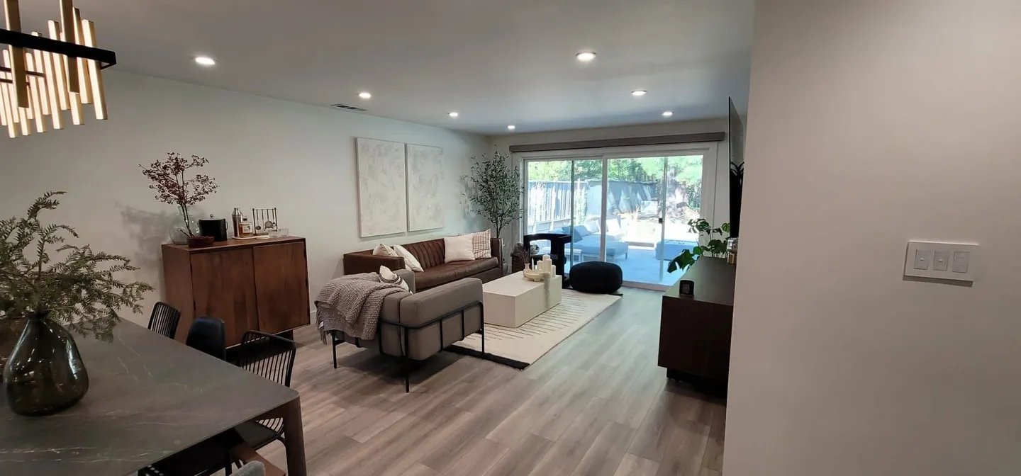 Modern living room with cozy seating and large window.